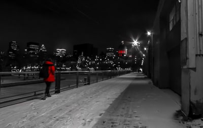 Person in a red coat walking in front of the city